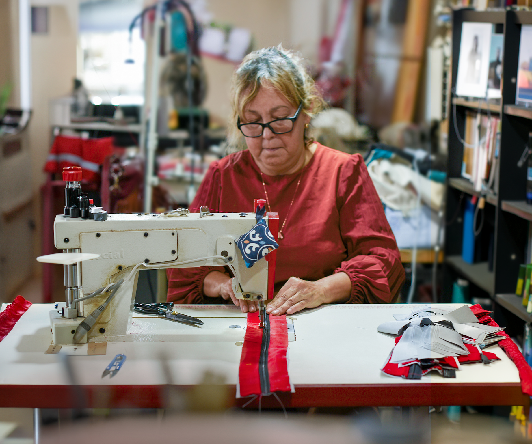 Costureira confeccionando novos produtos a partir de uniformes reutilizados no projeto Upcycling